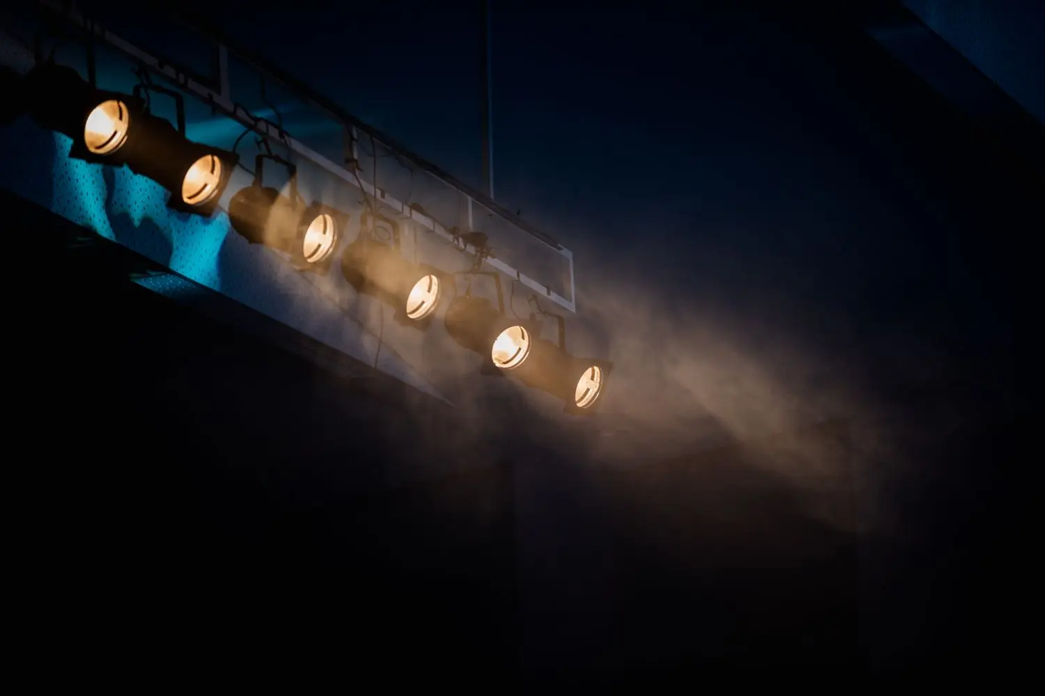 Warm theatre lights illuminating a dark stage