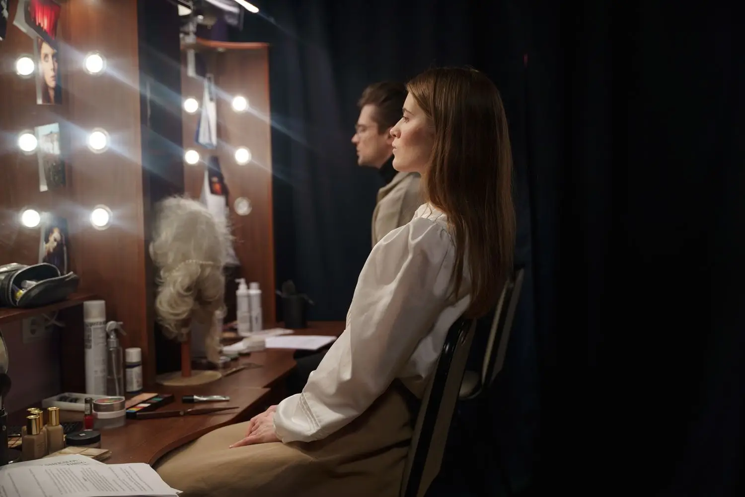 Actor preparing backstage beside dressing room lights
