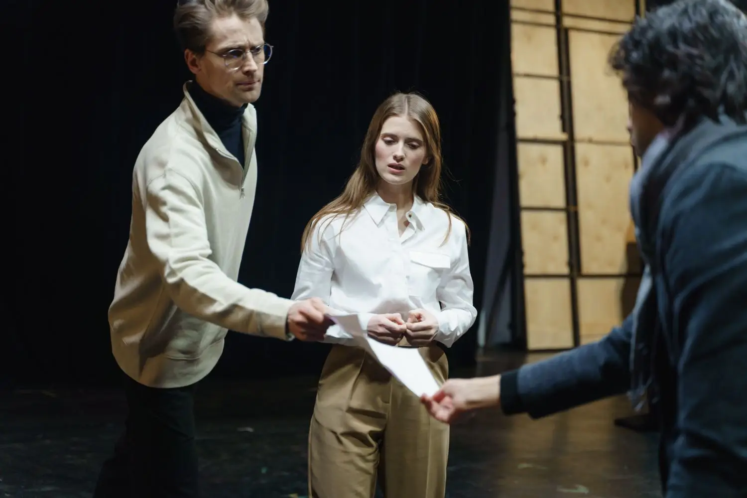 Director giving detailed notes to actors during a stage rehearsal