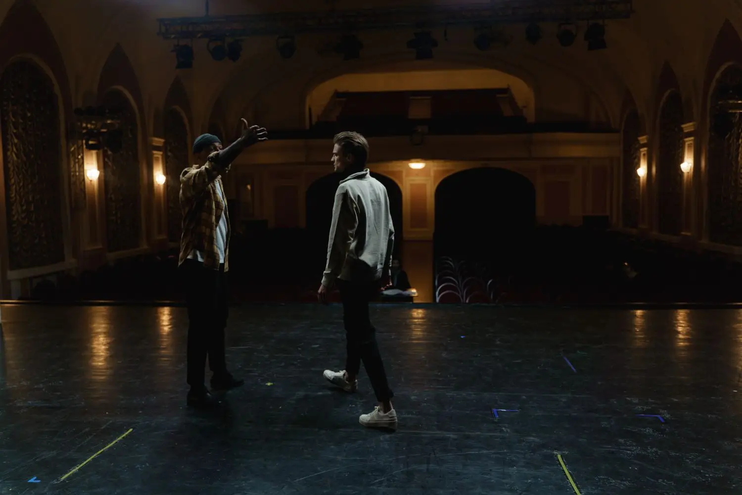Two performers rehearsing in an auditorium