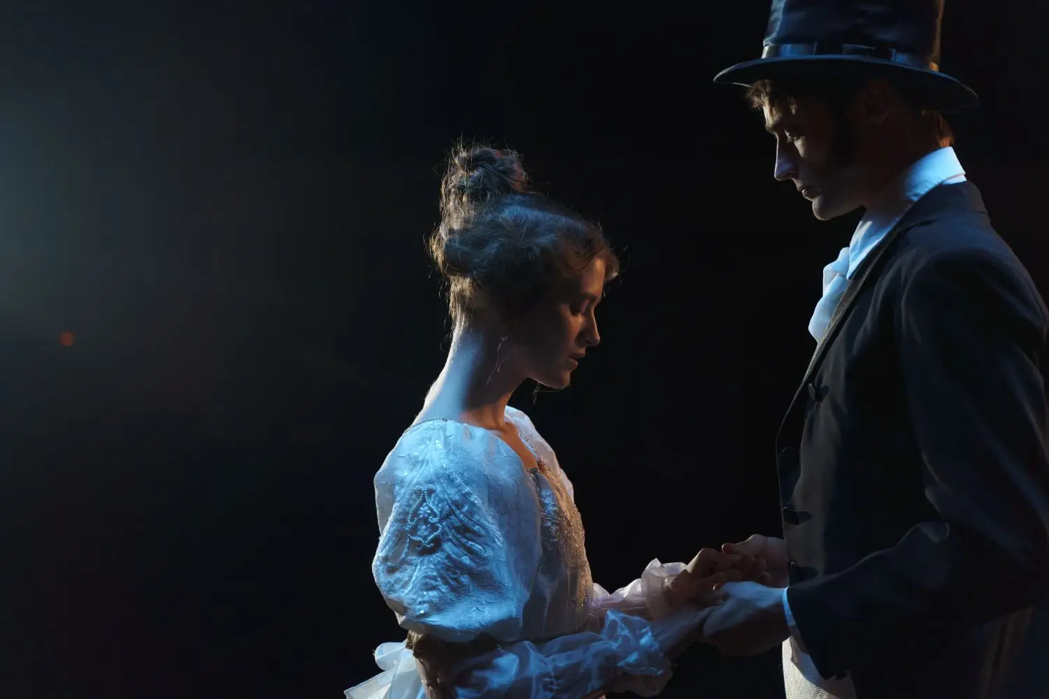 Two actors performing under stage light