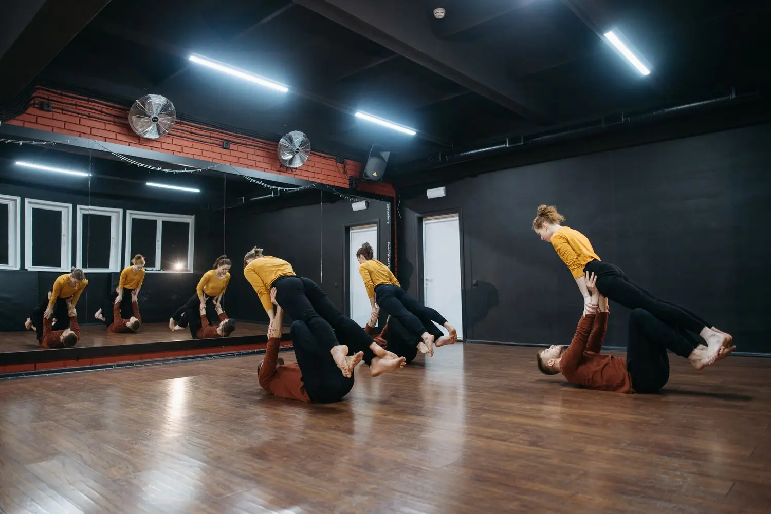 Performers training movement together in a studio