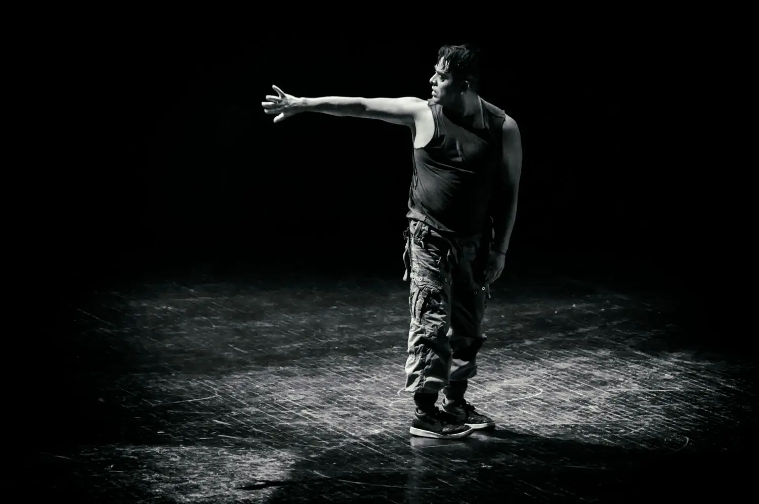 Performer practicing movement under a spotlight